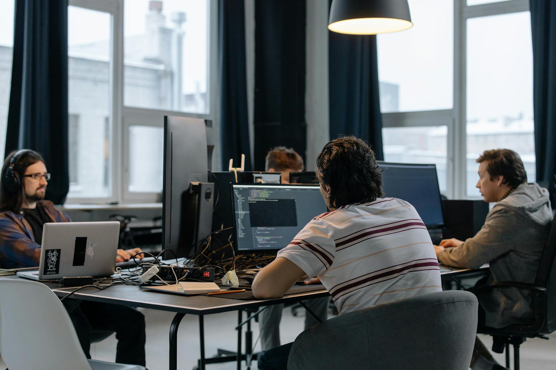 Zespół programistów pracuje przy komputerach w nowoczesnym biurze tech
