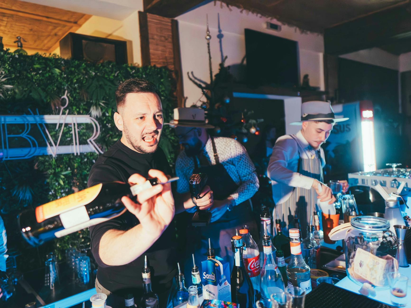 Barmani przygotowują kolorowe koktajle przy barze nocnego klubu