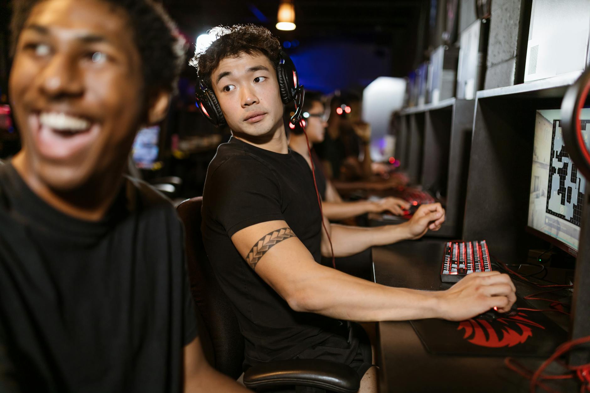 Młodzi gracze przy komputerach podczas turnieju MMO w hali e-sportowej
