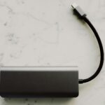 Powerbank 100W z kablem USB-C na marmurowym blacie, sprzęt w podróży