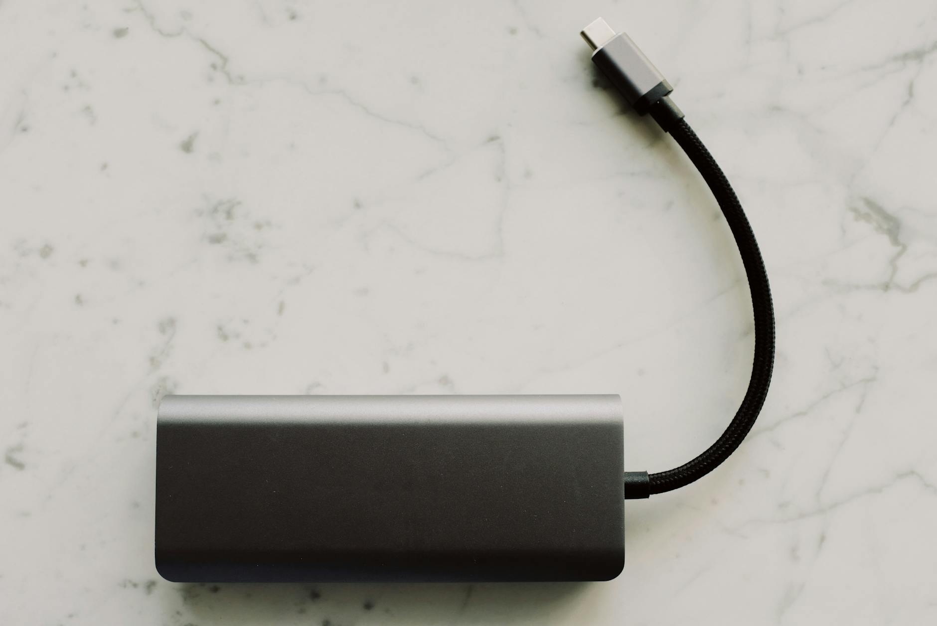 Powerbank z kablem USB-C leżący na marmurowym blacie