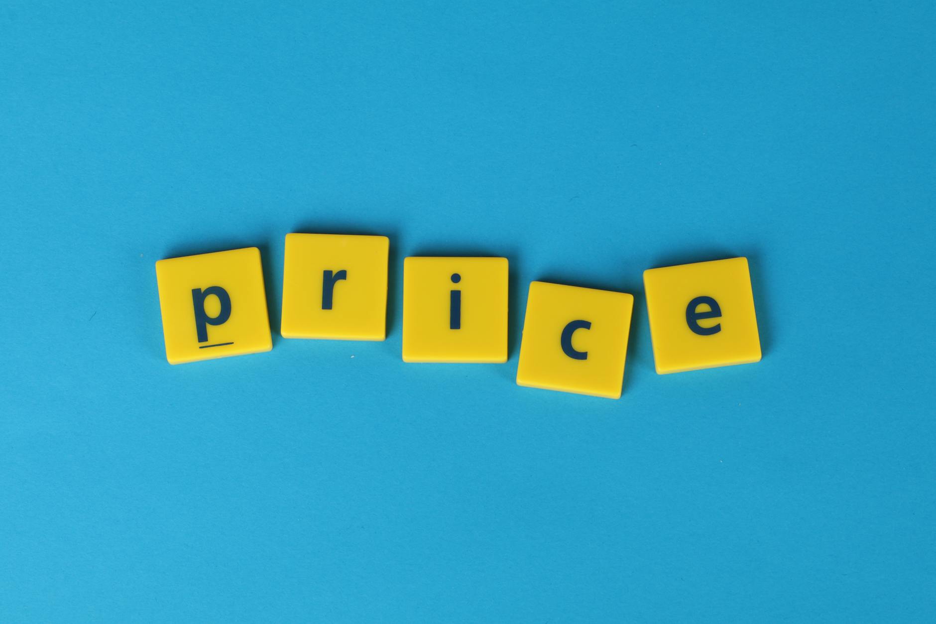 Żółte kostki z napisem price na niebieskim tle, symbol ceny produktu cyfrowego