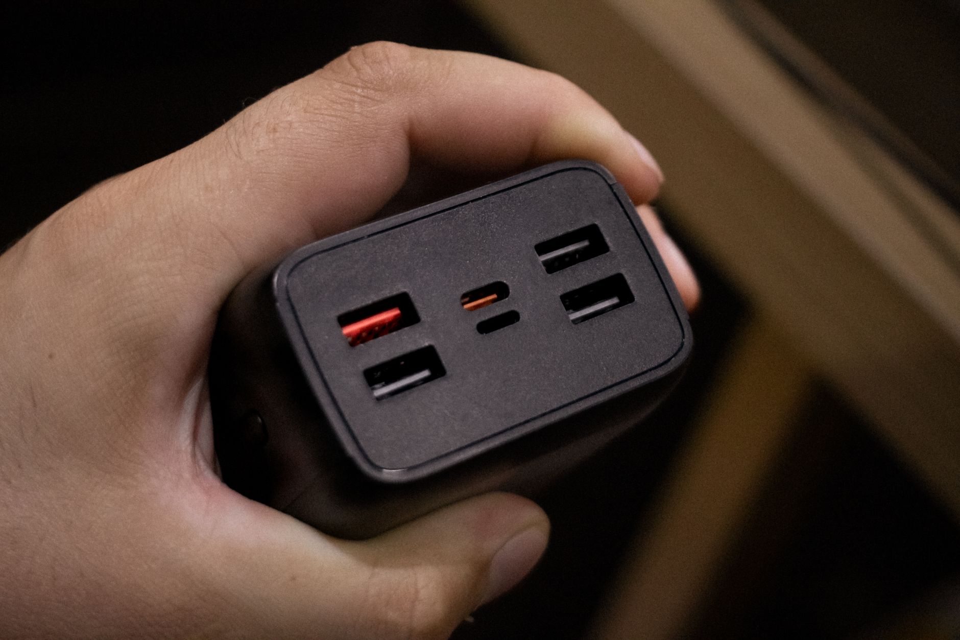 Dłoń trzymająca powerbank z kilkoma portami USB z bliska
