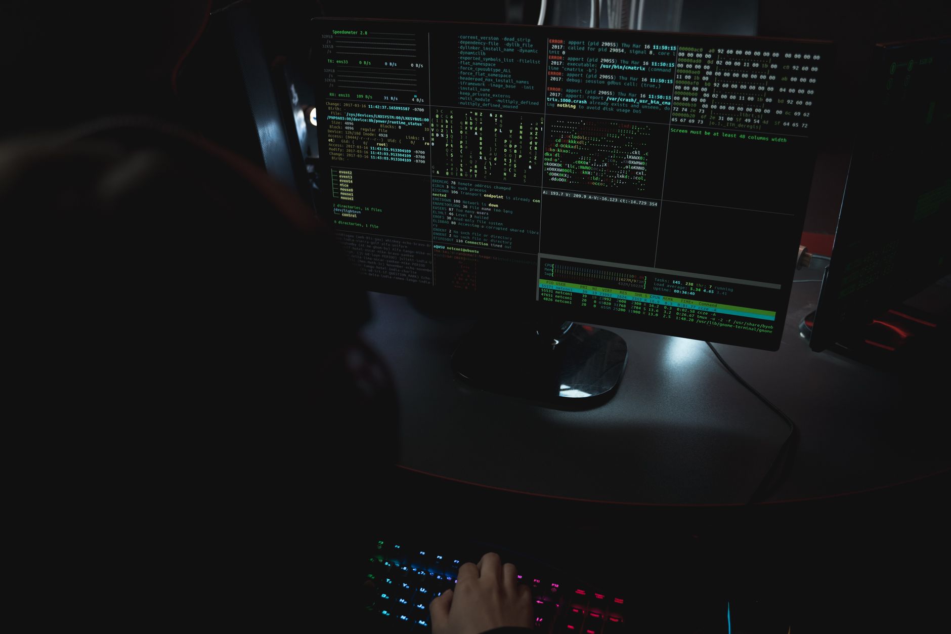 Monitory z kodem w ciemnym pokoju, stanowisko pracy cyberbezpieczeństwa